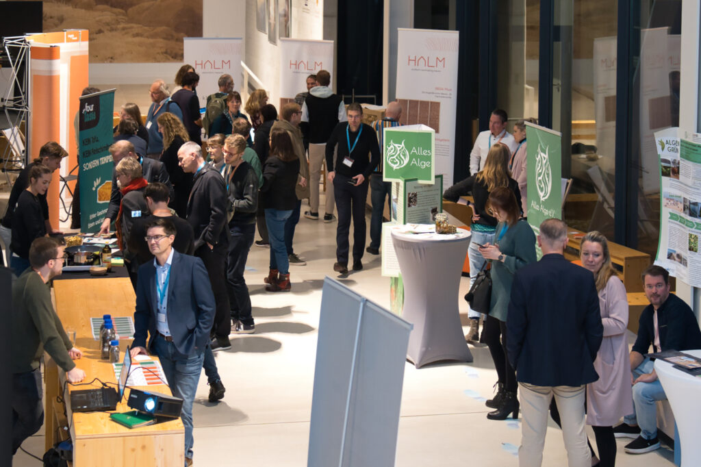 Gründungsteams stellen ihre Ideen an Ausstellungsständen vor und kommen mit Gästen ins Gespräch.